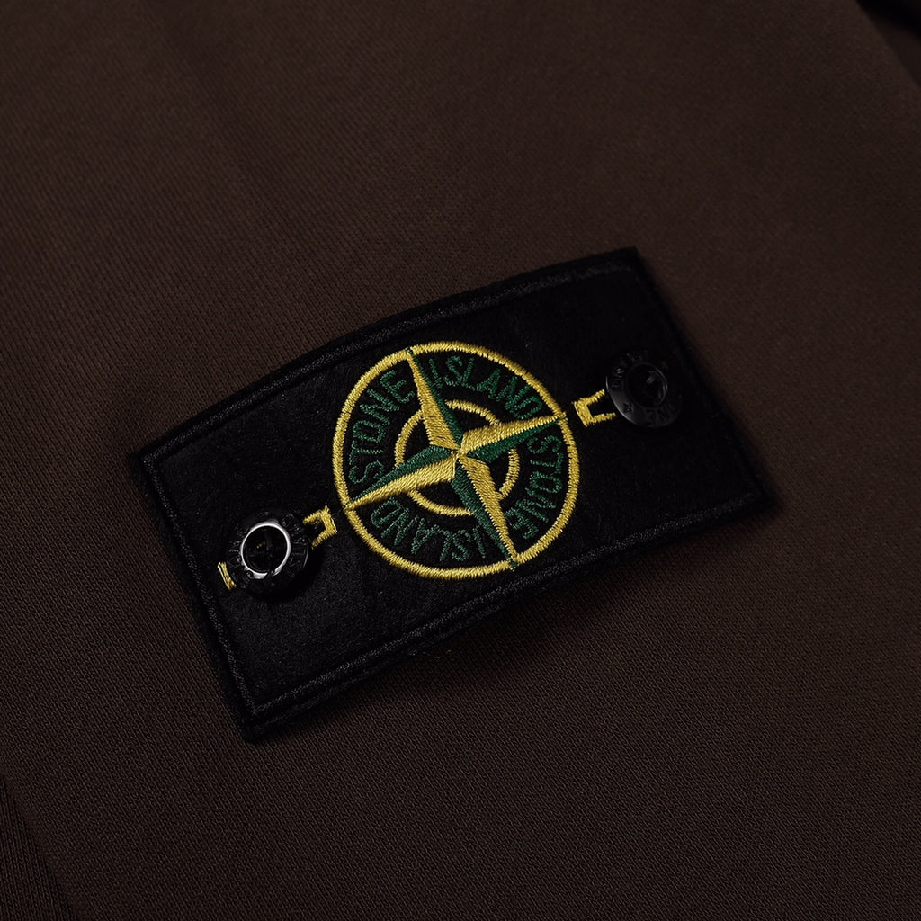 Stone Island embroidered sleeve patch on dark brown sweatshirt