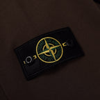 Stone Island embroidered sleeve patch on dark brown sweatshirt