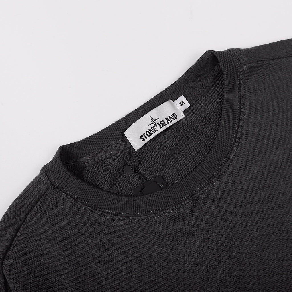 Crewneck sweatshirt neckline with Stone Island branded tag, dark black rib knit