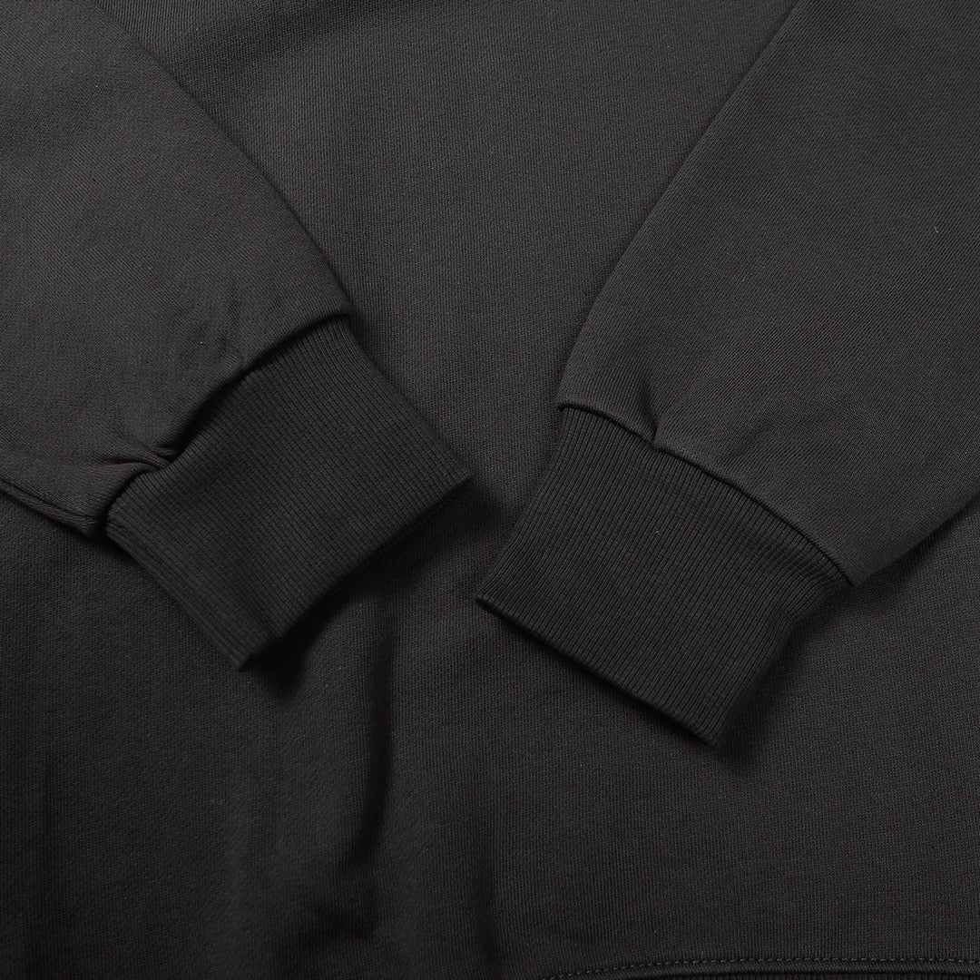 Crewneck sweatshirt ribbed cuff and seam stitching close-up, dark black knit