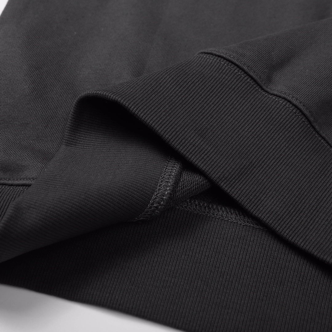Crewneck sweatshirt fabric close-up, dark black knit texture with ribbed cuff