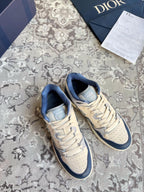 Dior unisex lace-up sneakers in cream and navy with CD logo detail.