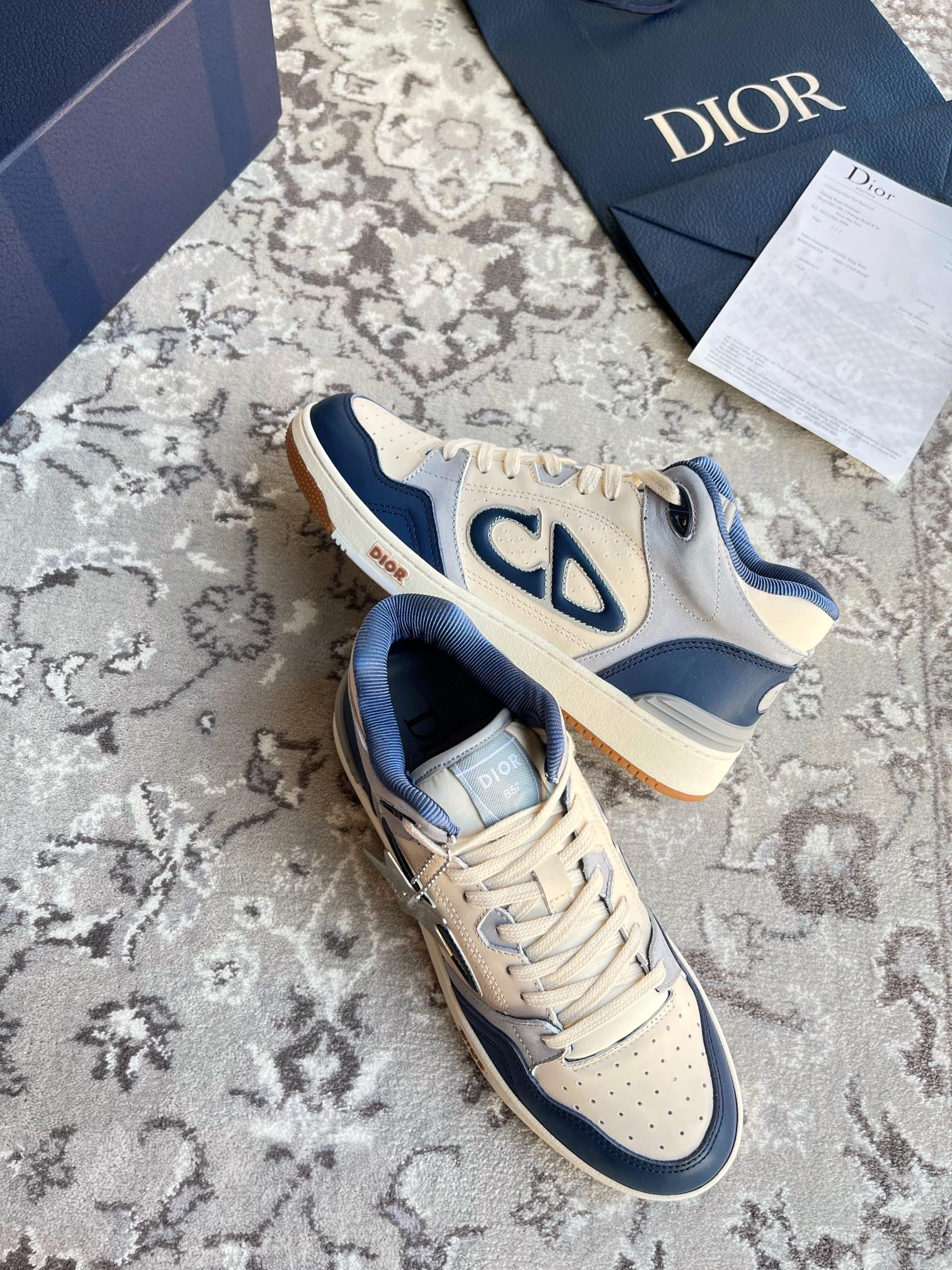 Dior unisex lace-up sneakers, cream and navy, with CD emblem on the panels.