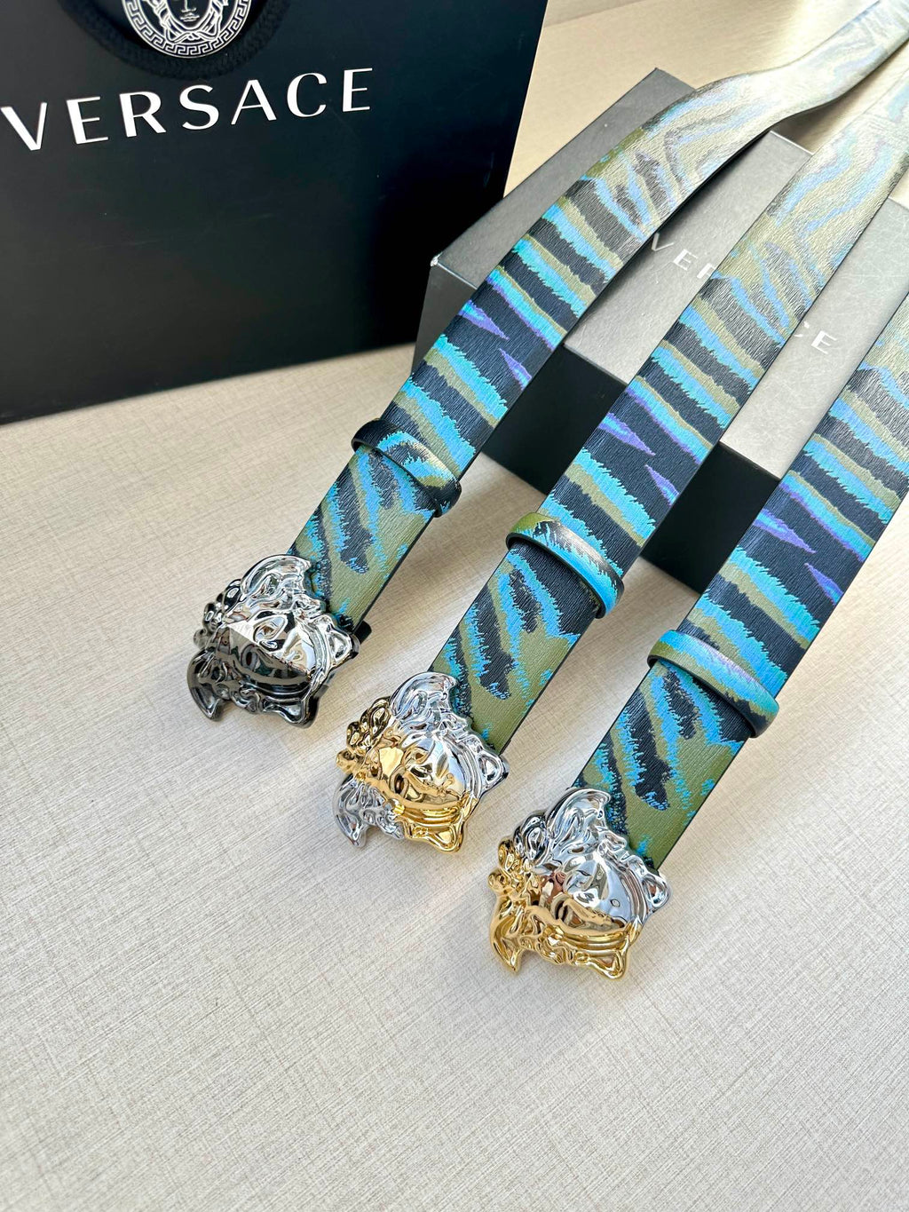 Versace belt with blue and teal patterned straps and ornate Medusa buckles (silver and gold-tone)
