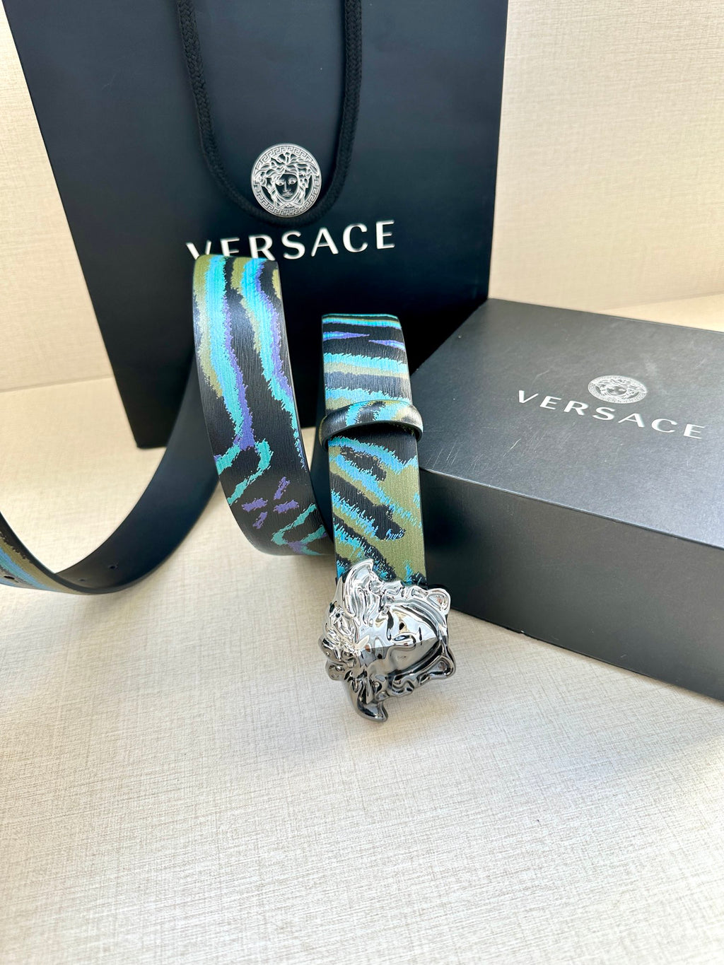 Versace belt with blue and teal patterned strap and silver Medusa buckle, hanging end