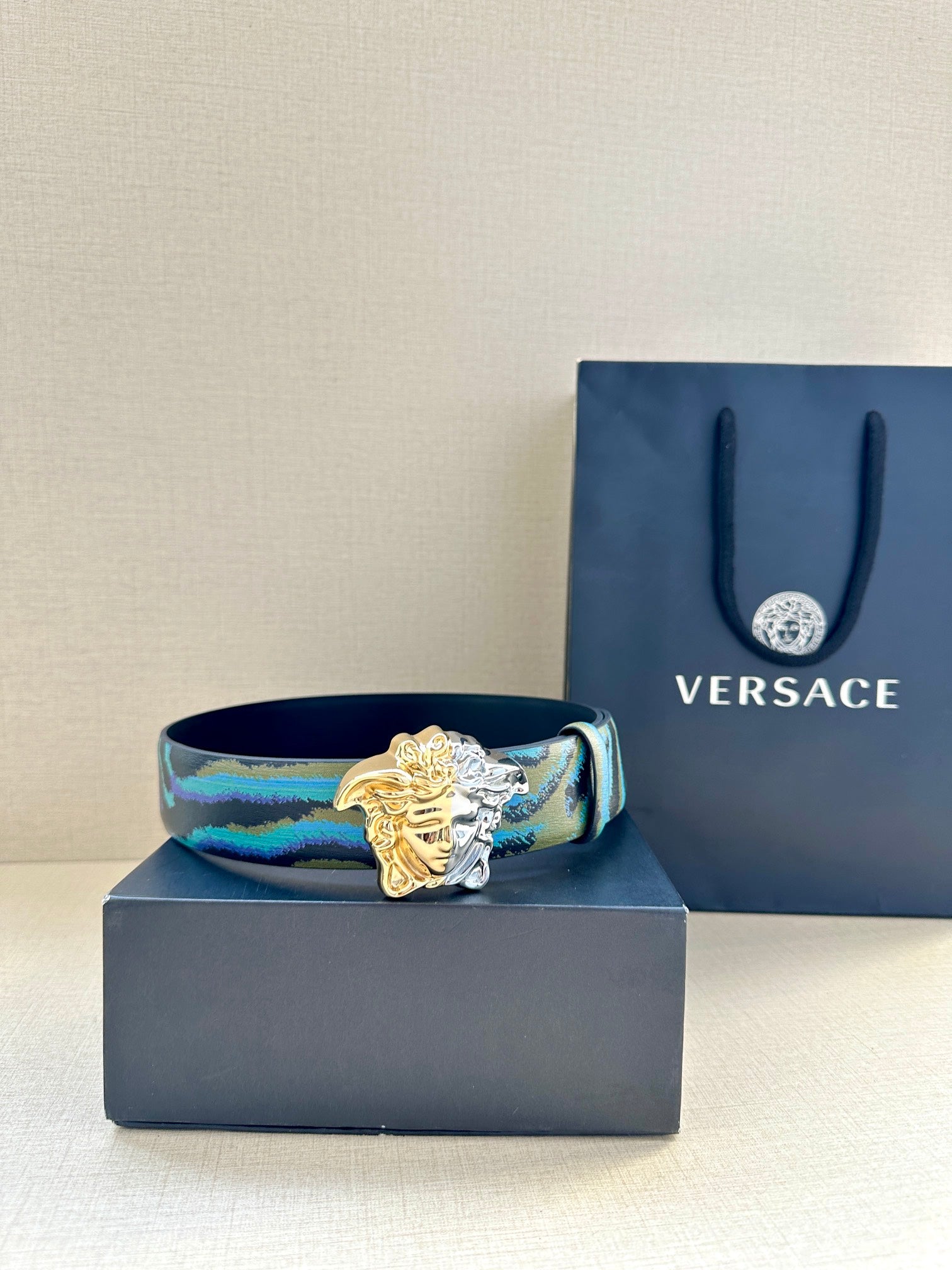 Blue patterned leather belt with ornate gold Medusa buckle detail