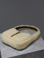 YSL shearling flat bag with loop handle, cream teddy fabric and brown leather clasp tab