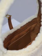 YSL shearling bag close-up: brown leather interior panel with gold-tone hardware