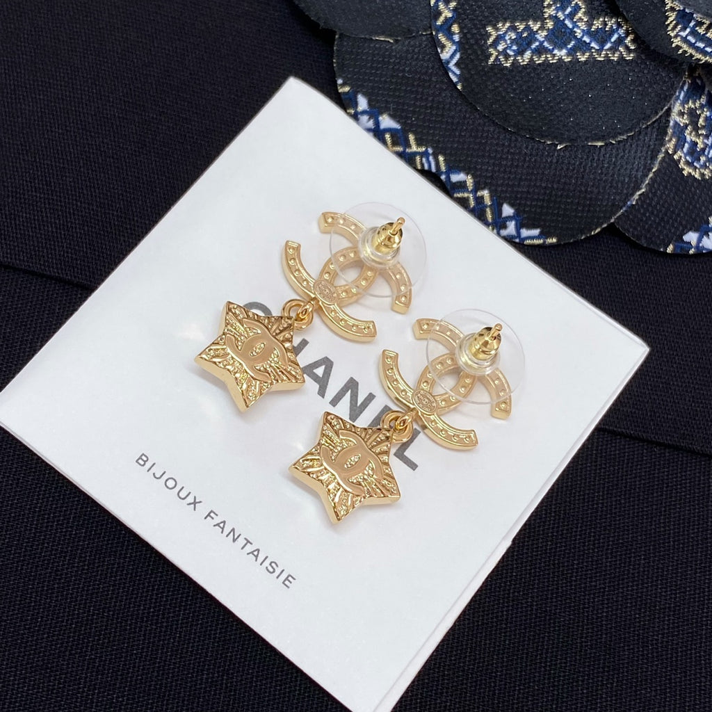 Gold-tone CC star charm earrings with white enamel stars and rhinestone trim on card