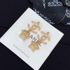 Gold-tone CC star charm earrings with white enamel stars and rhinestone trim on card