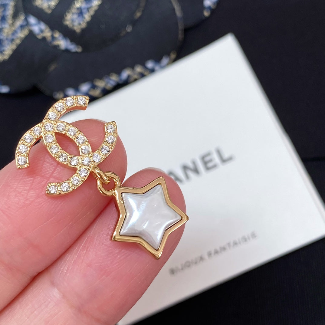 Gold-tone CC star charm earring with white enamel star and rhinestone details
