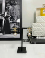 Gold-tone CC star drop earrings on stand with white enamel star centers