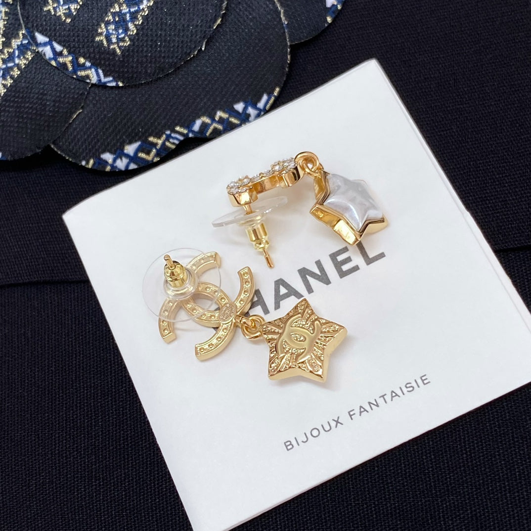 Gold-tone CC star charm earrings with white enamel stars and rhinestone details on card