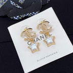 Gold-tone CC star drop earrings with white enamel stars and rhinestone trim on card