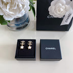 Pair of gold-tone CC star drop earrings in black gift box, white enamel stars