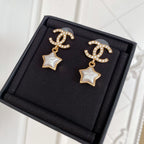 Gold-tone CC star drop earrings with white enamel stars and rhinestone accents