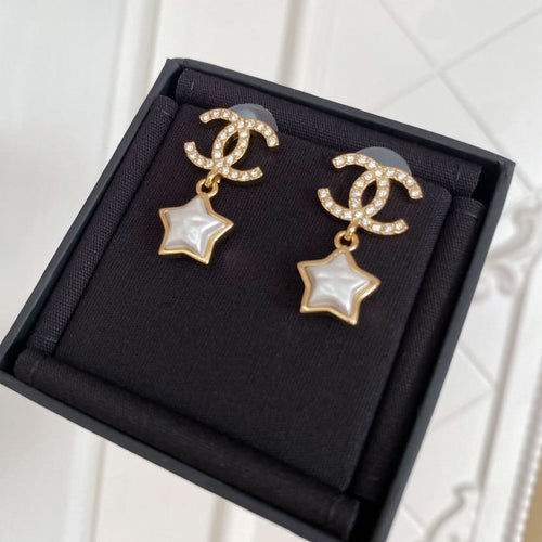 Gold-tone CC star drop earrings with white enamel stars and rhinestone accents