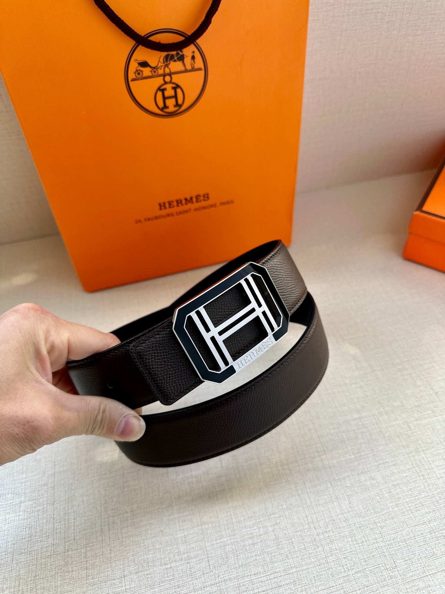 Black leather belt with textured strap and rectangular H buckle