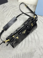 Black leather crossbody bag with long strap, gold-tone zipper pulls, and emblem hardware