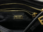 Black fabric lining with Prada Made in Italy label and gold zipper pull