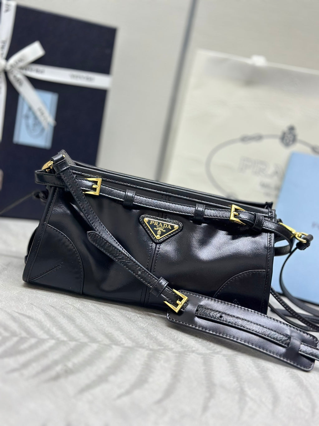 Black Prada leather shoulder bag with gold-tone hardware and top handle strap