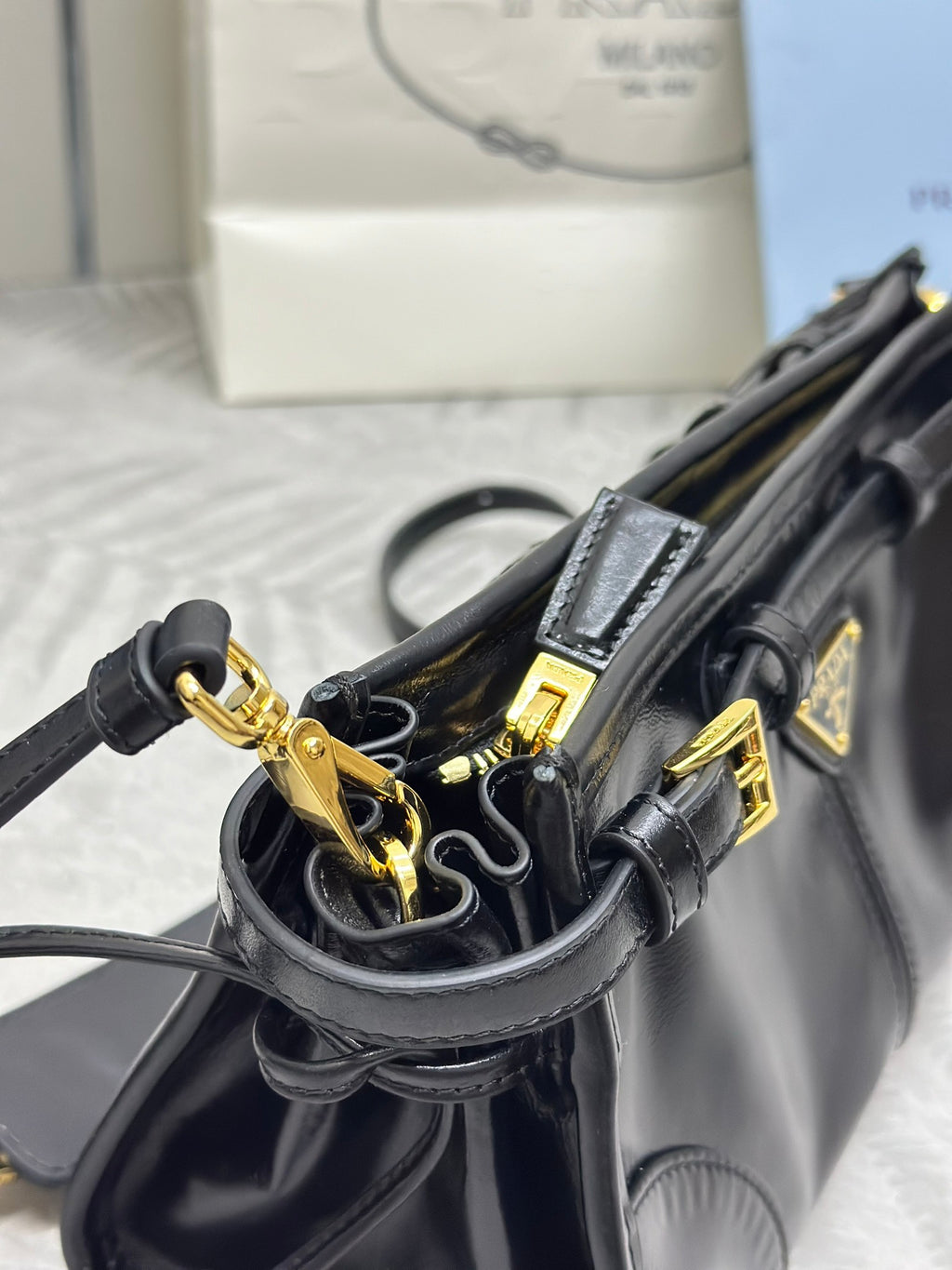 Black leather bag with gold-tone rings and straps hardware, open interior view