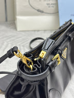 Black leather bag with gold-tone rings and straps hardware, open interior view