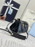 Black leather satchel bag with adjustable shoulder strap and gold-tone buckle accents