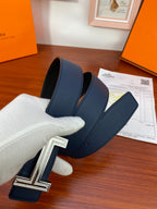 Blue leather belt with textured strap and silver H buckle in hand-held view