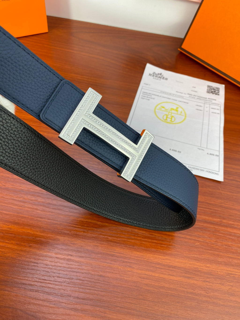 Navy leather belt with large square H buckle on center strap