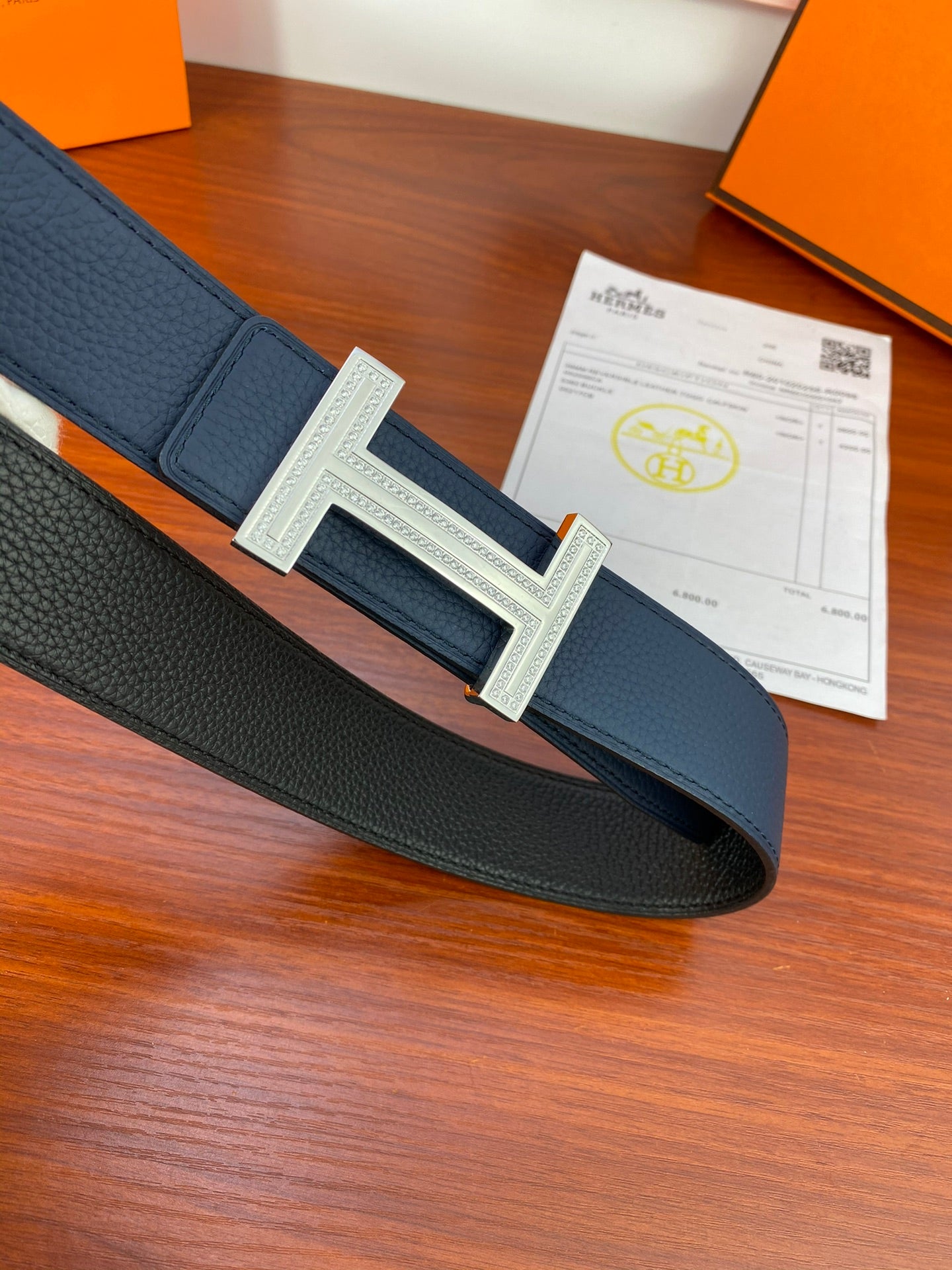 Navy leather belt with large square H buckle on center strap