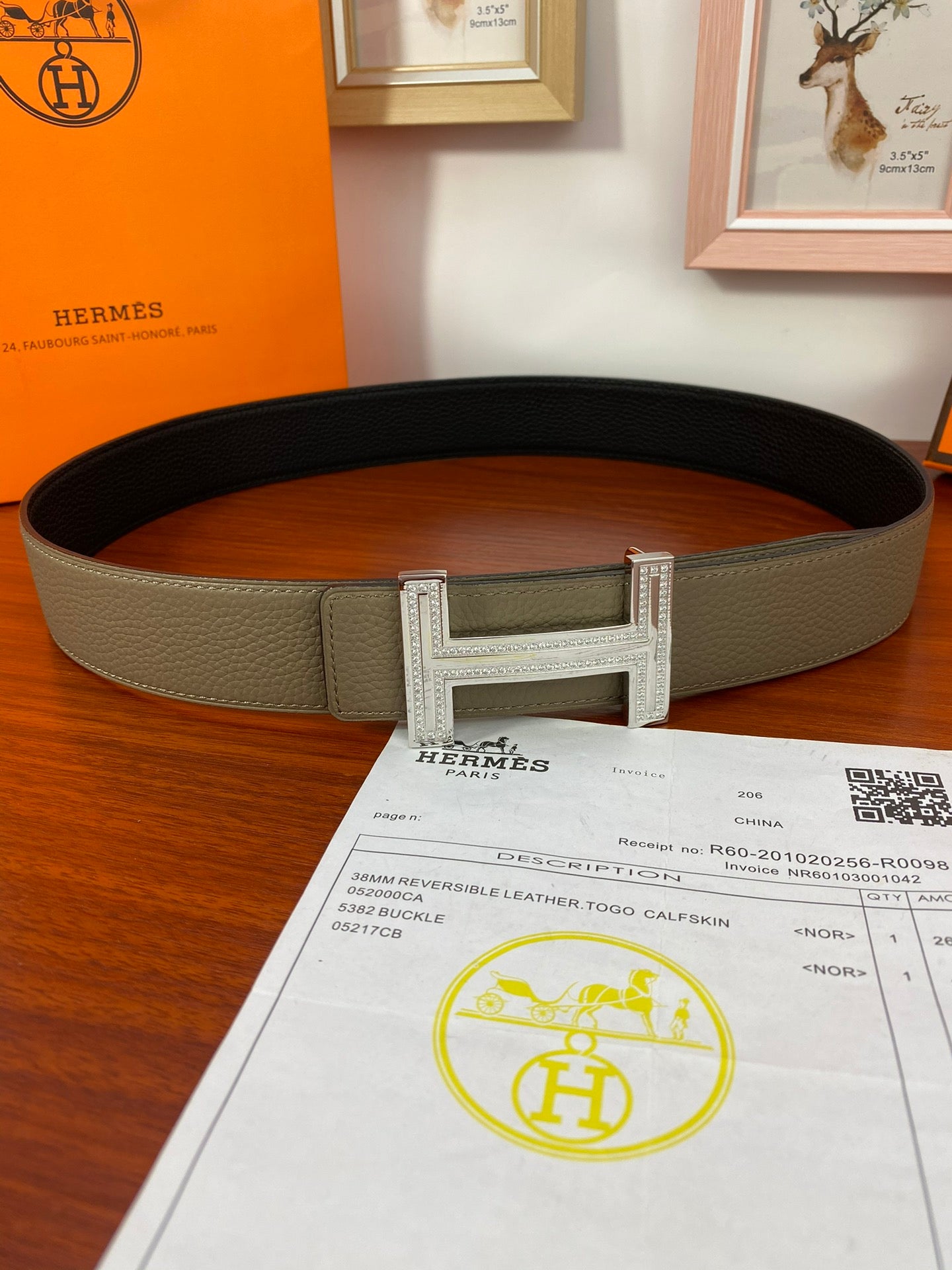 Hermes reversible belt with light olive strap and dark underside, silver buckle across center