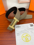 Hermes reversible belt with light olive strap and silver H buckle, plus matching buckle keeper