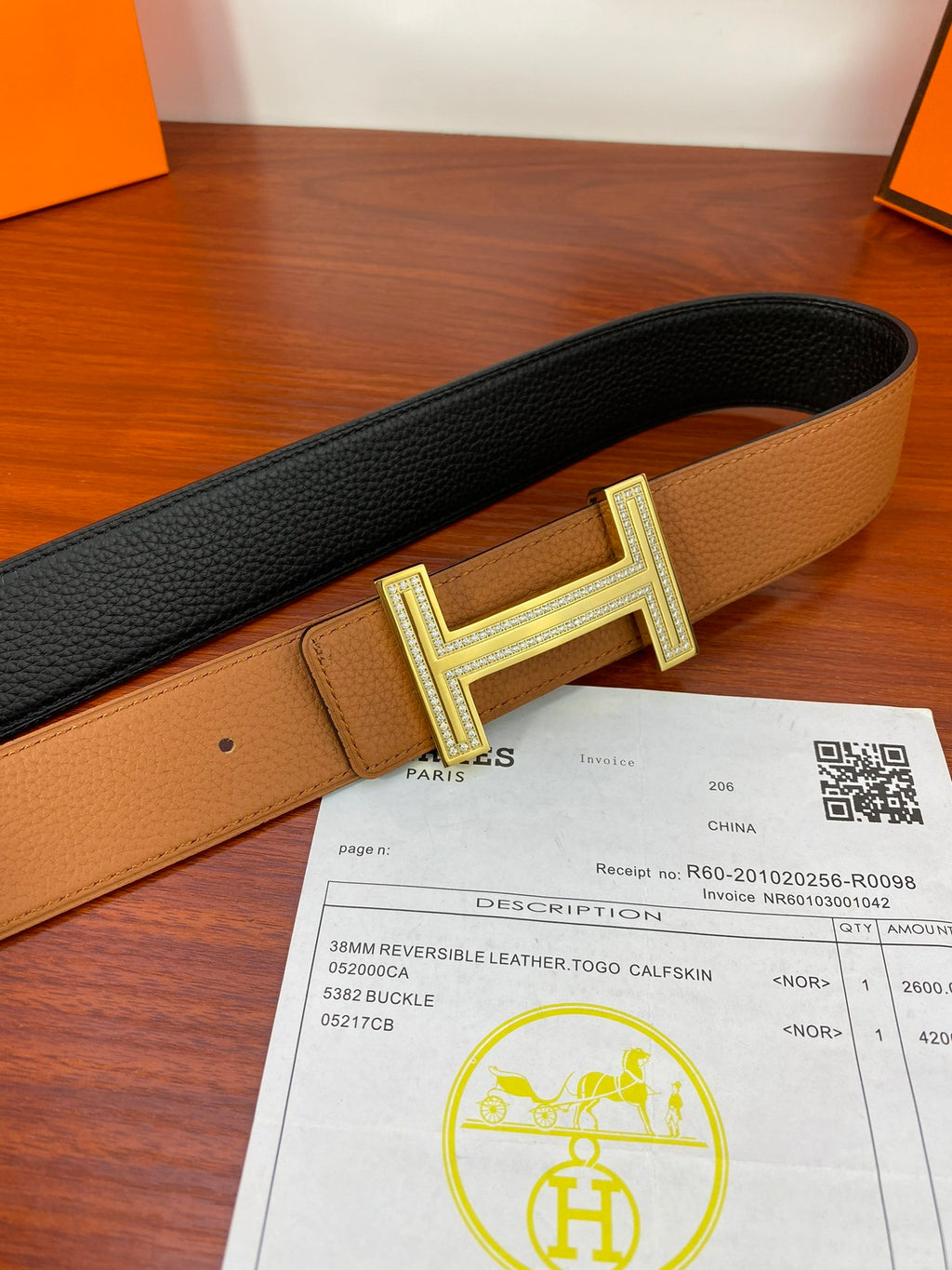 Reversible leather belt with tan outer side, dark inner side, and silver H buckle.