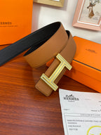 Reversible leather belt with tan and dark leather panels and silver H buckle.