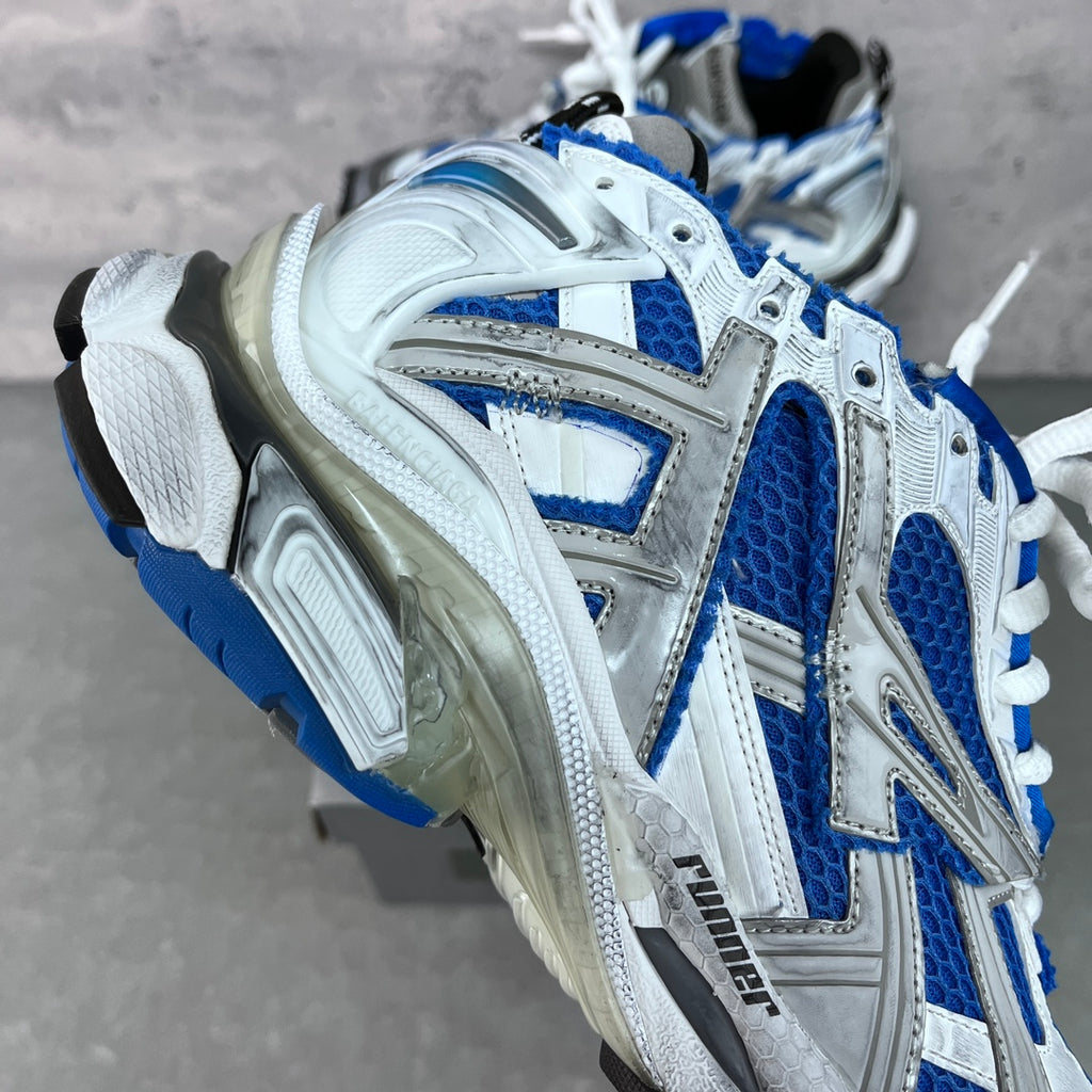 Unisex sneakers side view with blue accents, white upper and cushioned sole