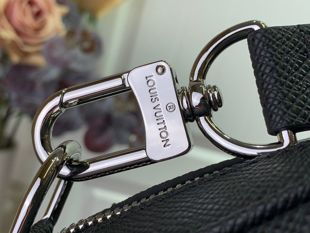 Louis Vuitton charm tag on metal clasp and leather-look strap loop