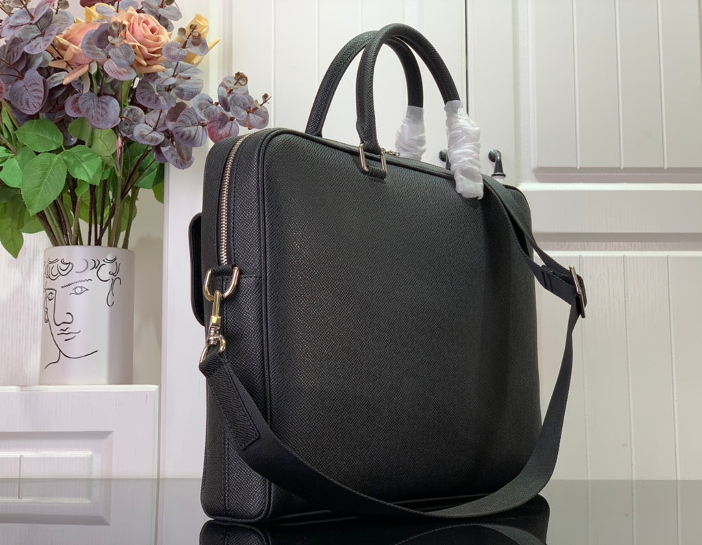 Black textured handbag with shoulder strap and side zip pocket, gold-tone hardware