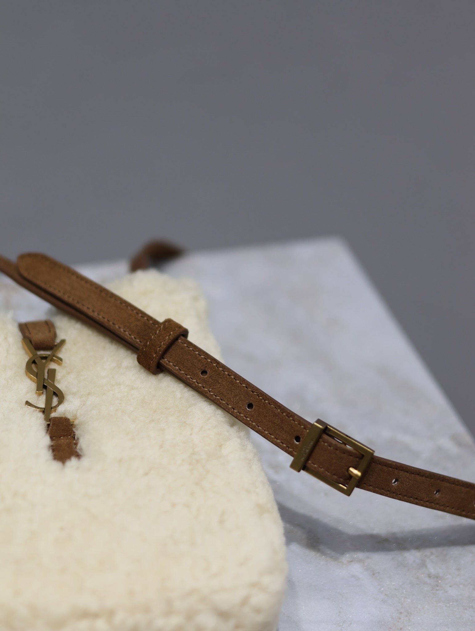 Brown leather shoulder strap with adjustable buckle and gold-tone hardware