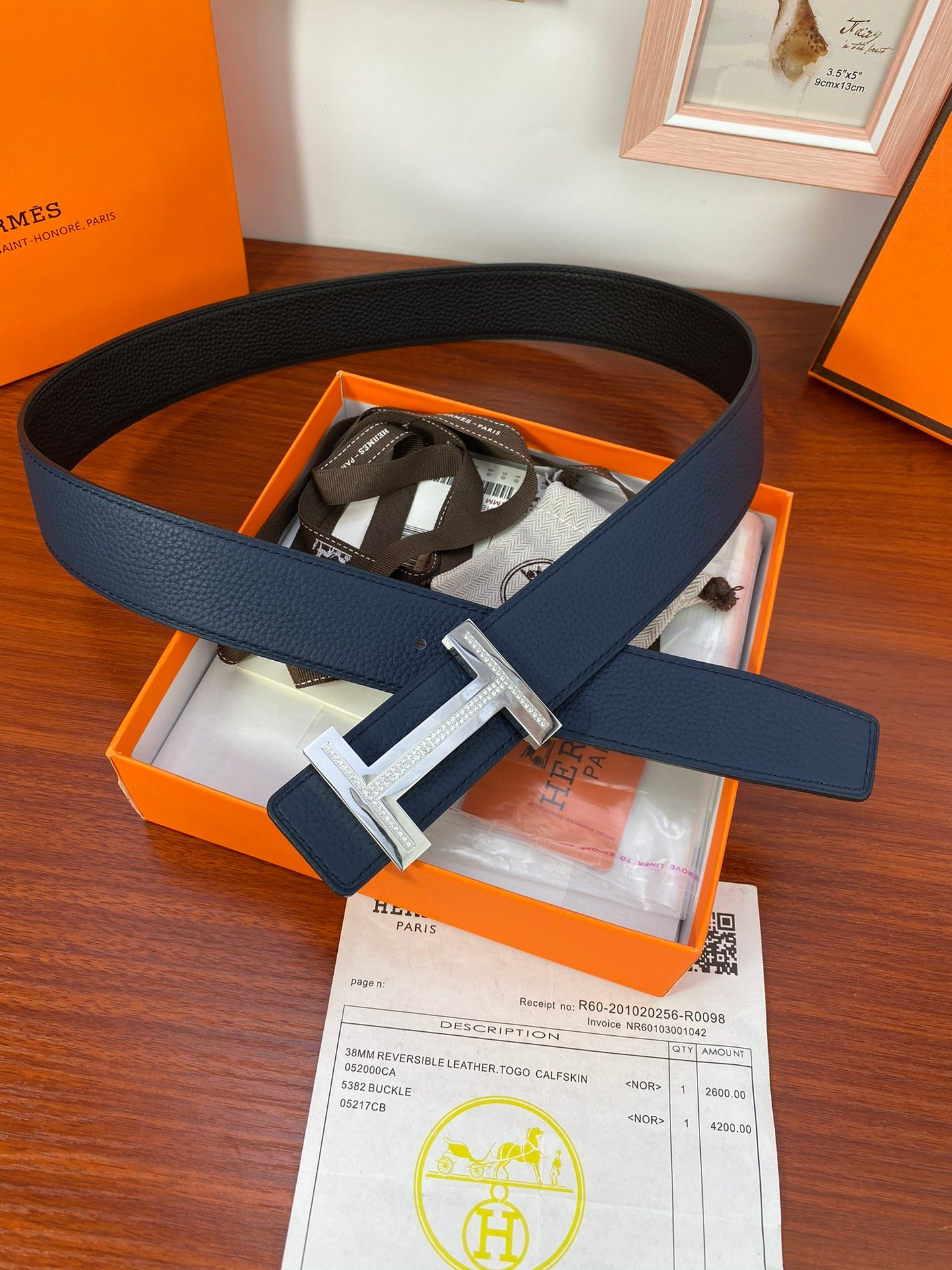 Hermès belt in dark blue leather with silver-tone buckle, shown in gift box.