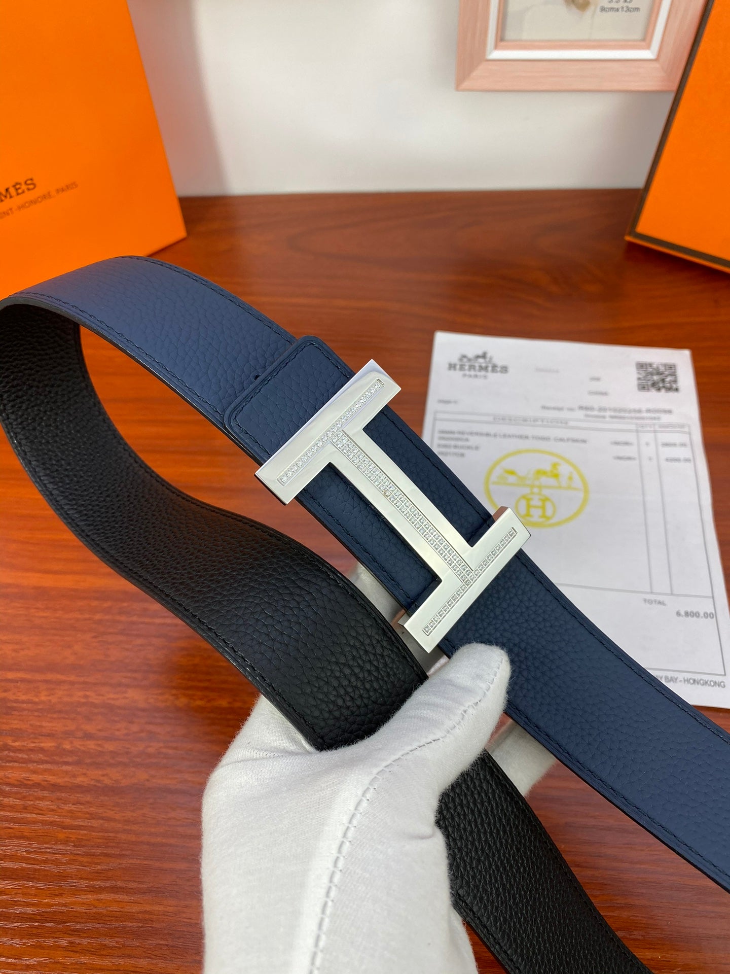 Hermès belt with dark blue leather strap and silver-tone H buckle.
