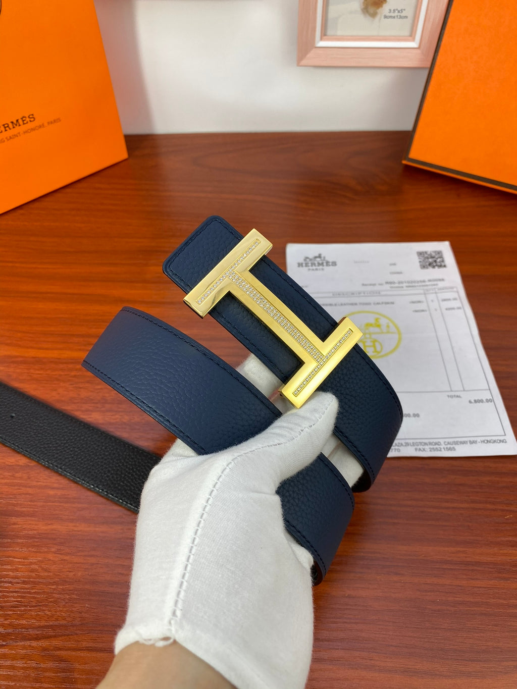 Hermès belt in dark blue leather with gold-tone H buckle.