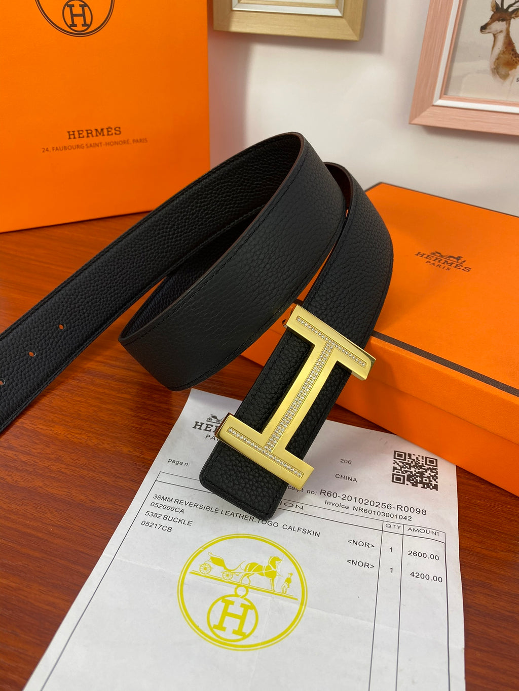 Black textured leather belt with gold H buckle and visible keeper