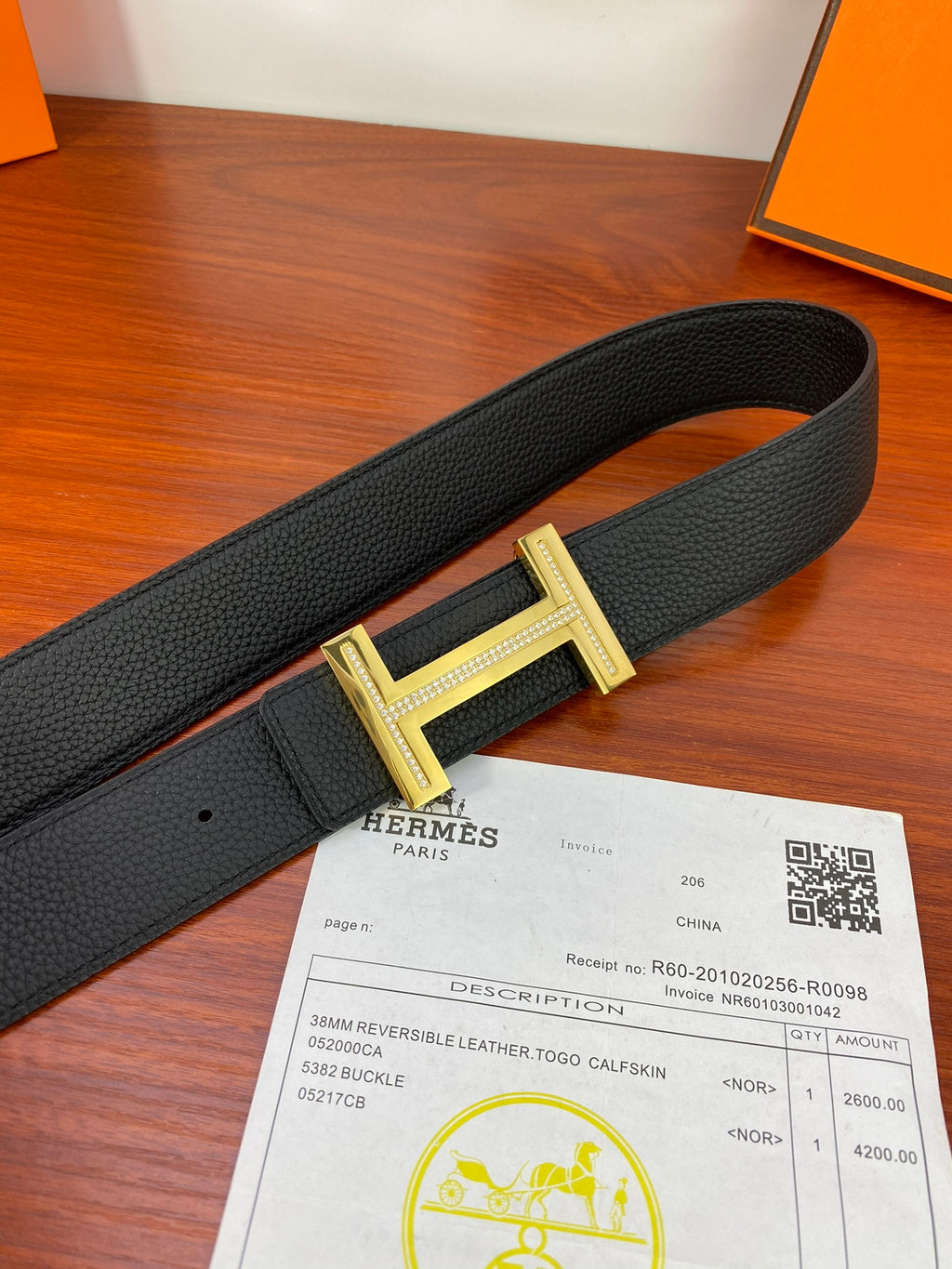 Black textured leather belt with gold H buckle and keeper
