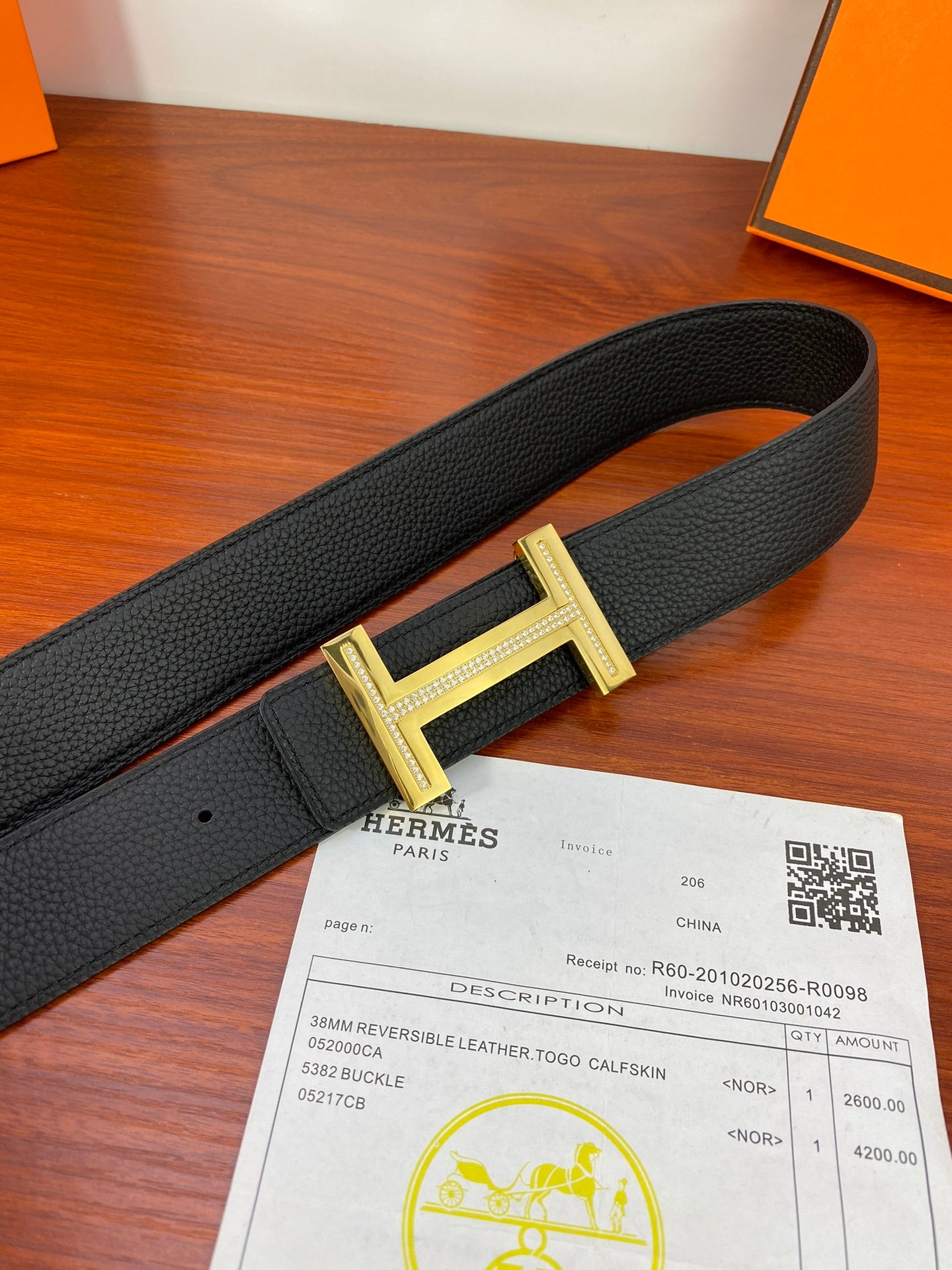 Black textured leather belt with gold H buckle and keeper