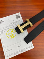 Black textured leather belt with gold H buckle and leather strap end