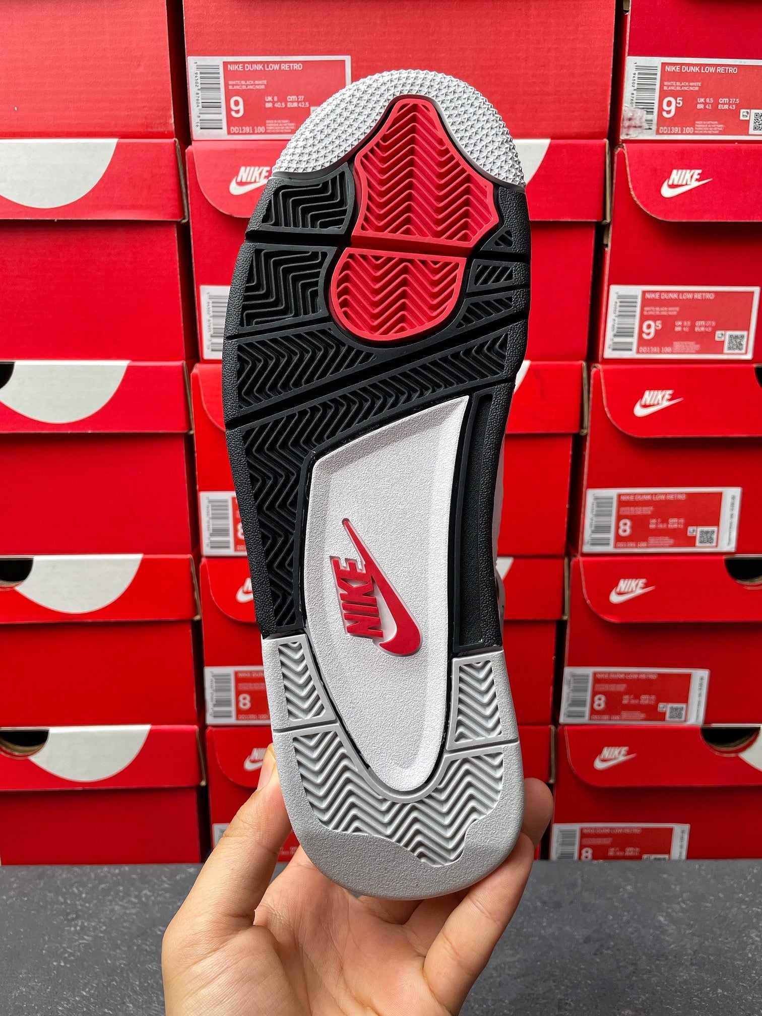 Black and gray outsole with red triangular traction pattern