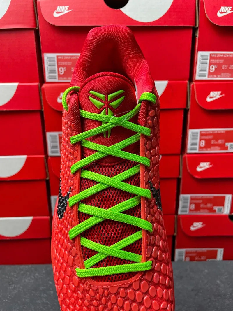 Red shoe upper with neon green lace-up and star emblem at laces, top view.