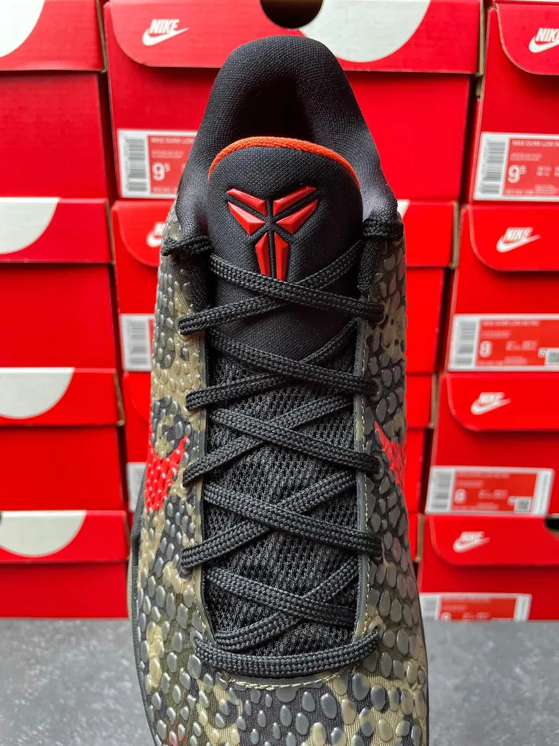 Mens basketball shoe front view, black laces and tongue with red emblem on heel patch