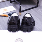 Back view of black Versace leather loafers with gold emblem and chunky tread soles